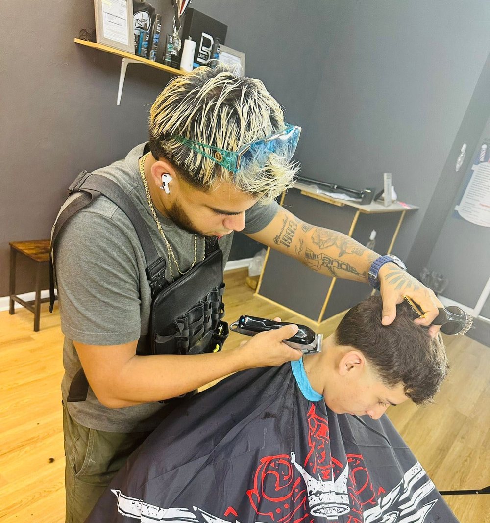 Barber at work inside AJ23 Barbershop